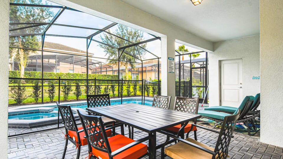 Enjoy alfresco dining by the pool in this screened patio area, perfect for gatherings or a peaceful evening retreat.