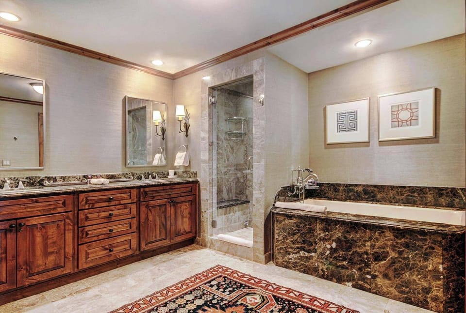 The primary bathroom boasts dual vanities, heated floors, a jetted tub, and a walk-in shower.