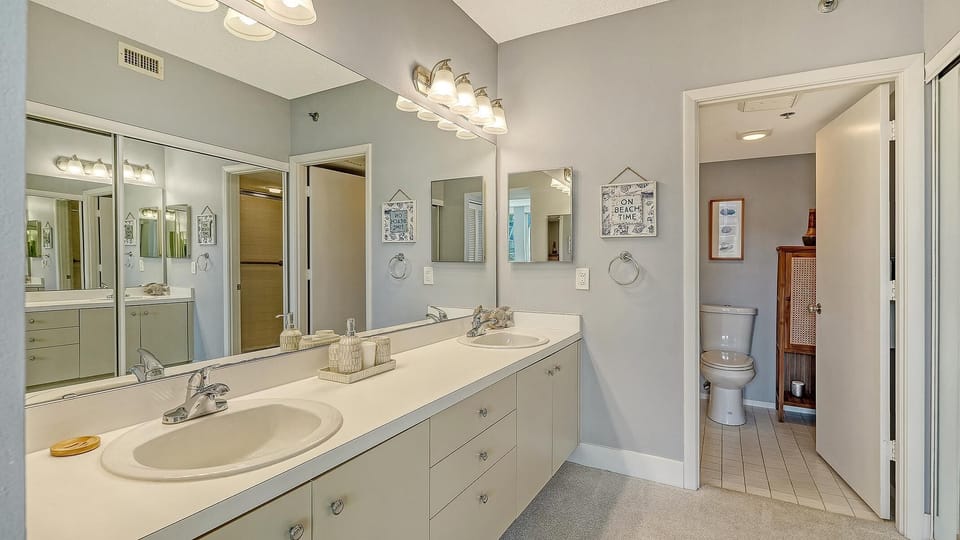 Spacious bathroom with dual sinks and bright vanity lighting