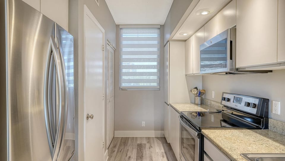 Sleek, modern kitchen with stainless steel appliances and bright lighting