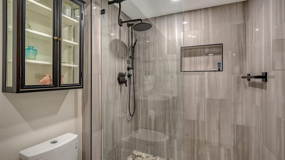 Modern glass-enclosed shower with rainfall and handheld fixtures