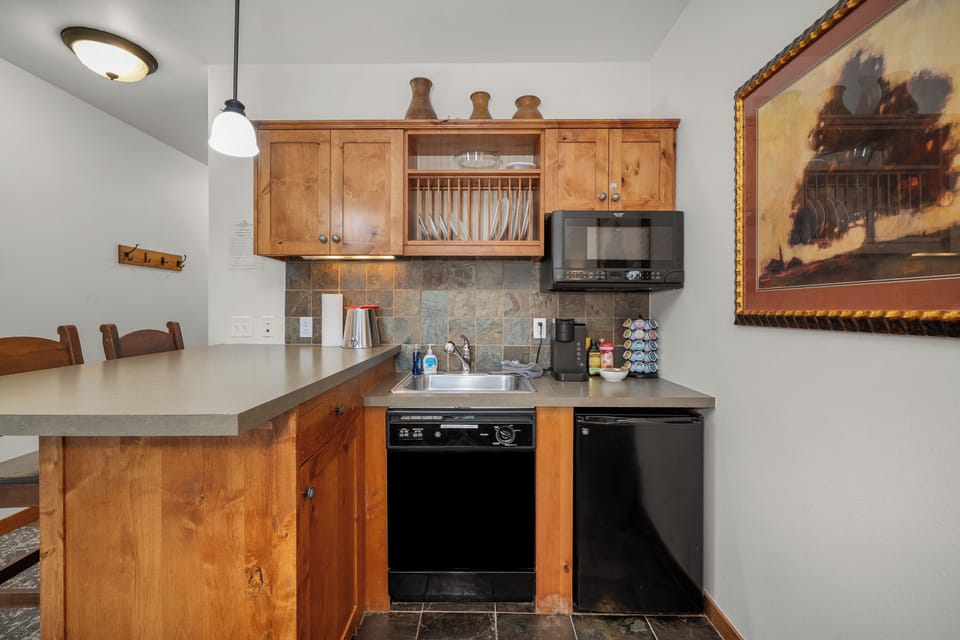 Cozy kitchenette with breakfast bar, coffee station, and warm wood finishes