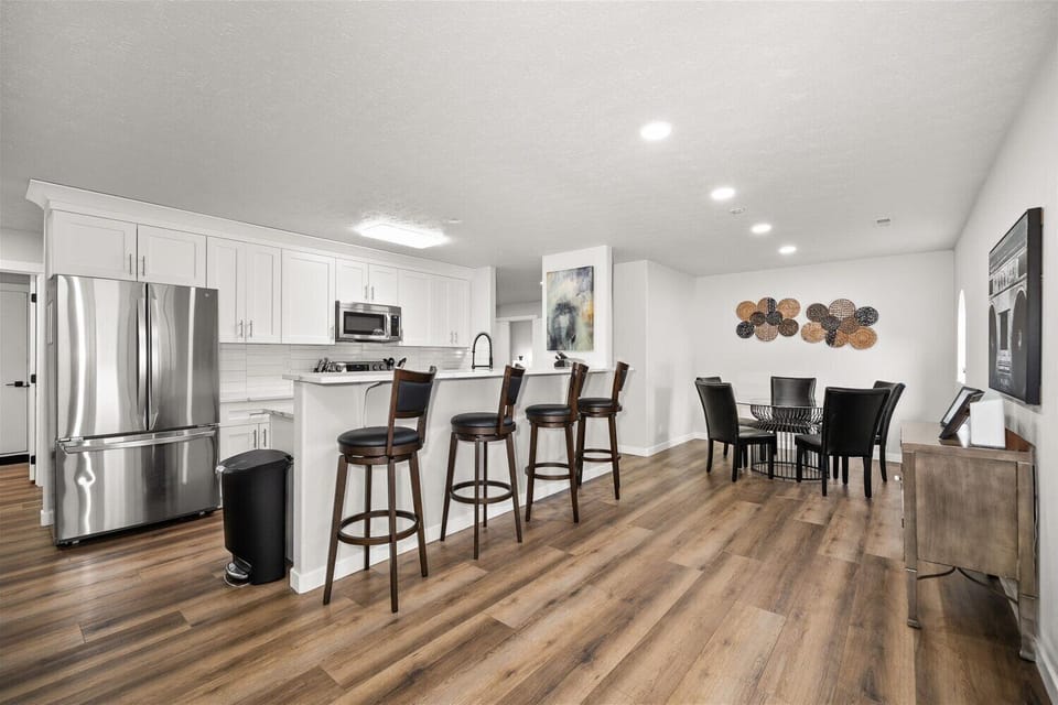 Bright open kitchen and dining space with bar seating for 4