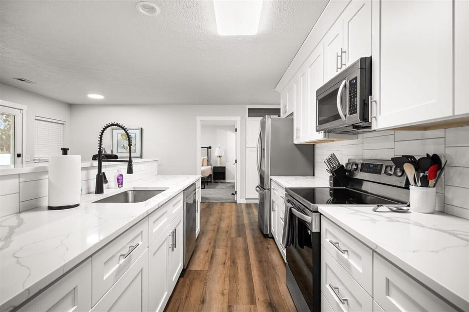 Bright modern kitchen with island, stainless appliances, and sleek finishes