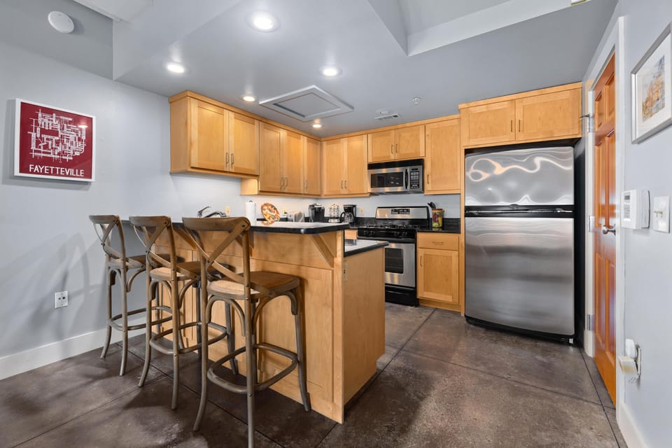 Modern kitchen with stainless steel appliances and breakfast bar seating