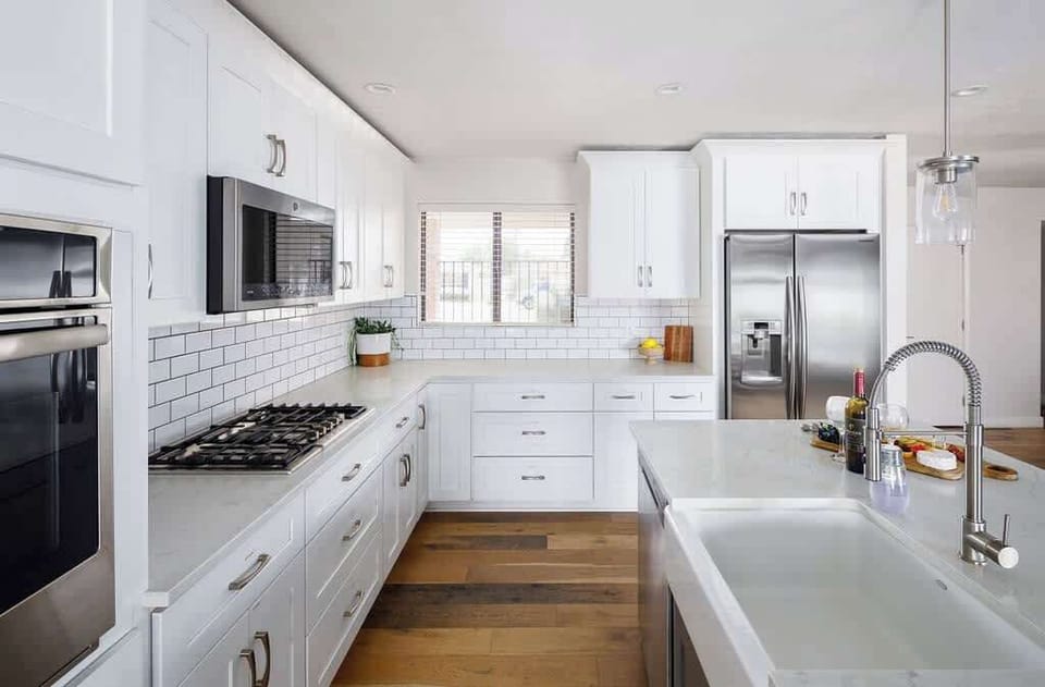 Fully equipped kitchen with stainless steel appliances, coffee bar, breakfast bar seating, and filled with basic cooking essentials.