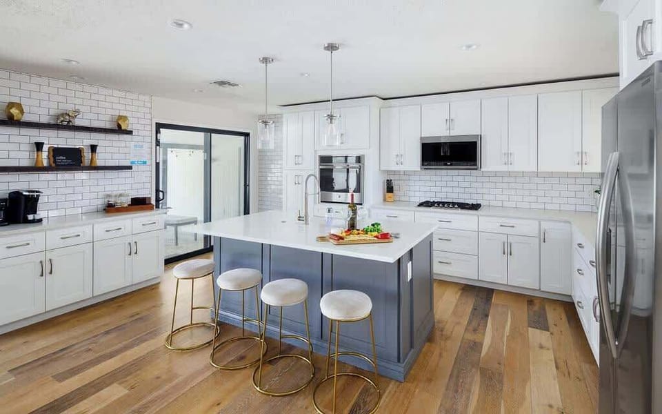 Fully equipped kitchen with stainless steel appliances, coffee bar, breakfast bar seating, and filled with basic cooking essentials.