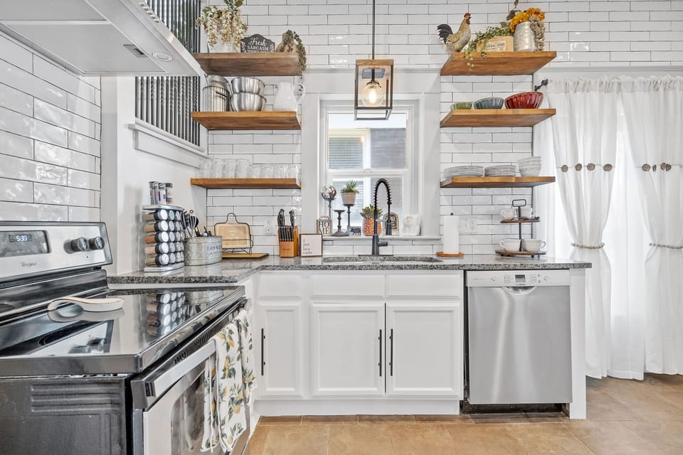 Bright, fully equipped kitchen with stainless steel appliances, open shelving, and modern farmhouse touches—perfect for cooking before exploring Midtown KC or hopping on the Streetcar.