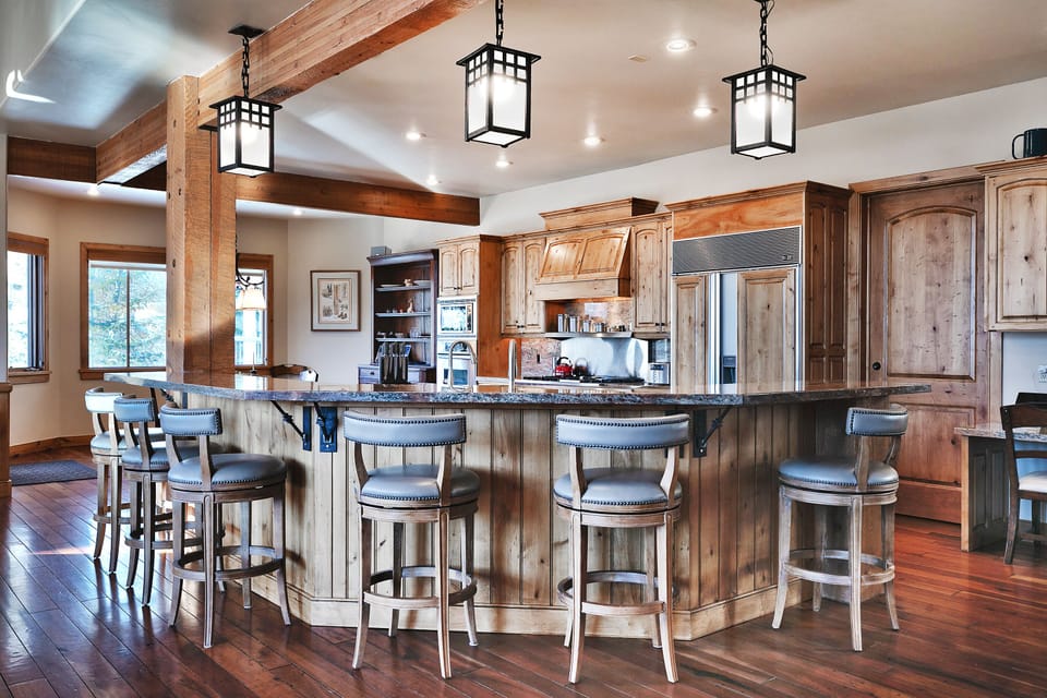 Two kitchen islands-one wrap around and one center island, both have sinks, medium wood cabinets, and granite countertops.
