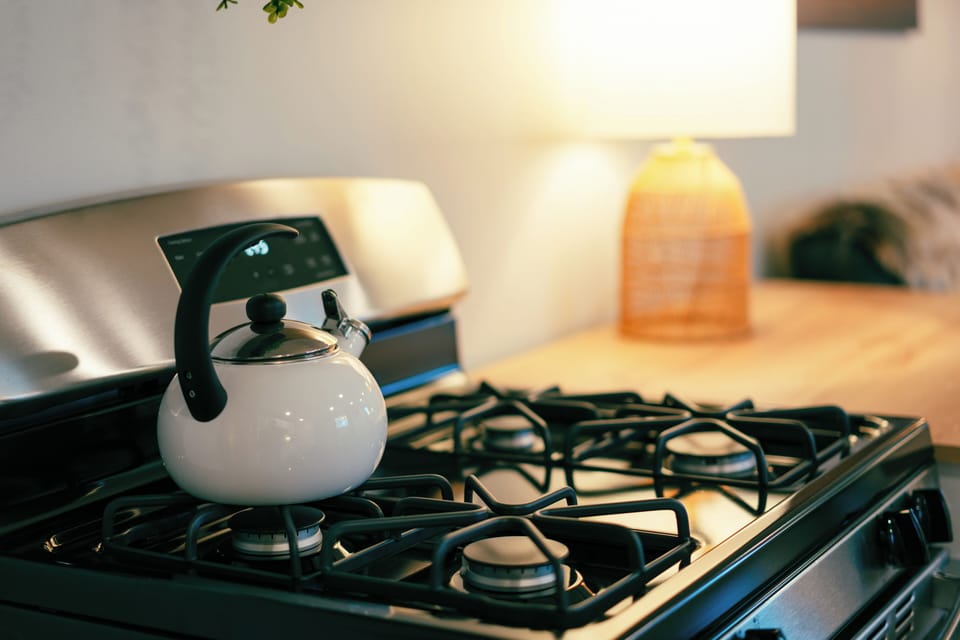 4-burner stovetop with full-size oven and wood table top for food preparation.