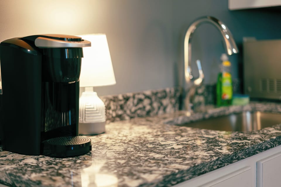 Keurig coffee maker sits atop lovely granite countertop.