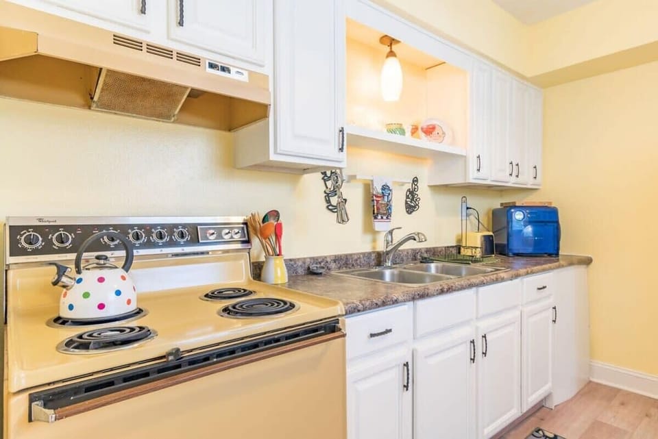 Bright kitchen with vintage stove and white cabinetry for a cozy cooking experience.