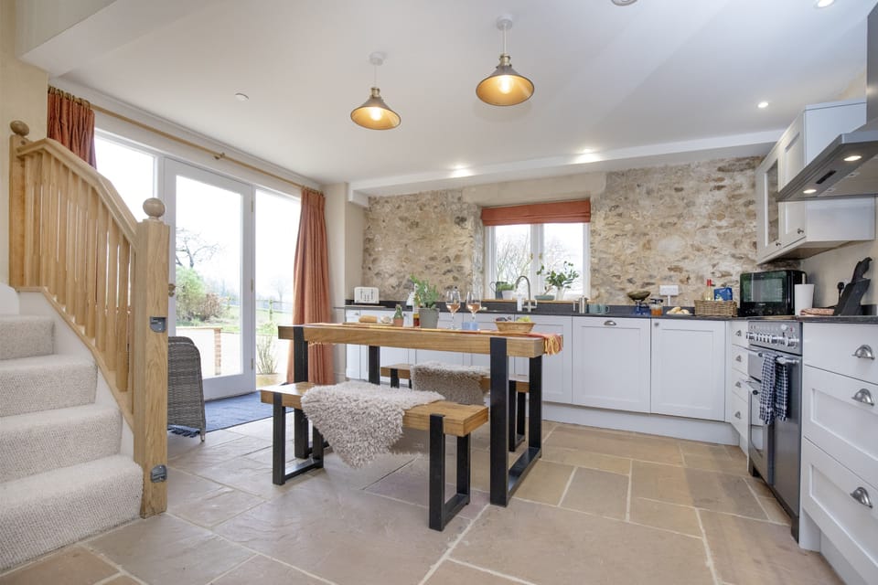 The Barn, Dorset: The dining kitchen is bright and airy with french doors offering views of the garden to the front
