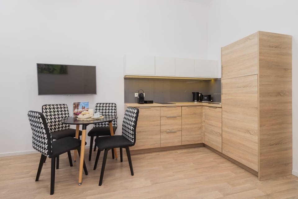 A small dining corner combined with a kitchen featuring wooden cabinets. The minimalist design emphasizes functionality and style.