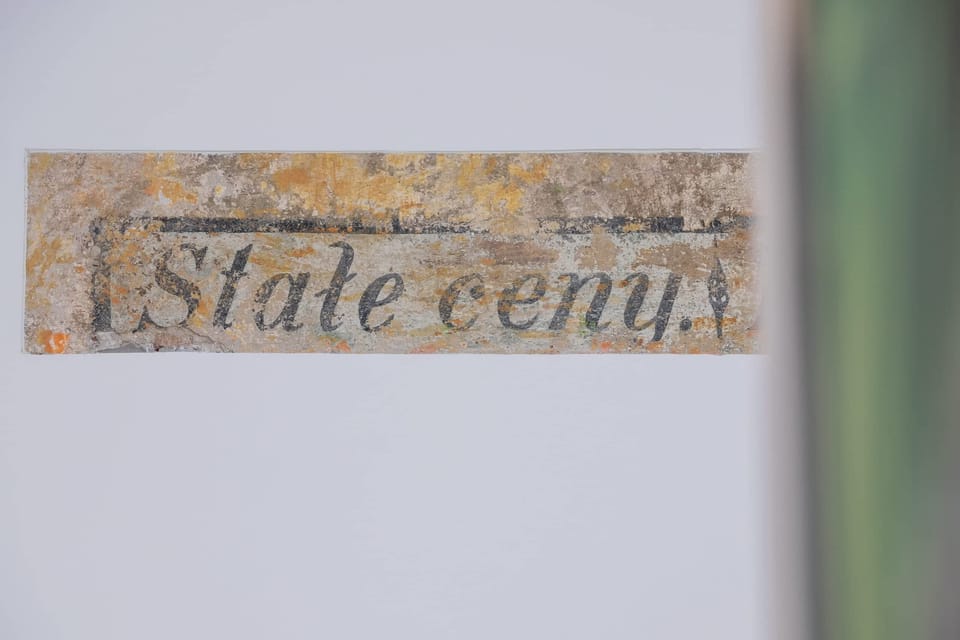 A close-up of a decorative sign with the words “Stałe ceny.” The texture suggests a vintage and artistic style.