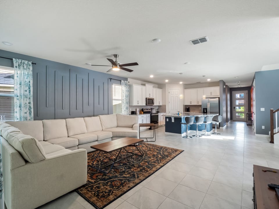 Spacious Downstairs Living Area with Comfy Soda, Flat Screen TV, Full Size Kitchen, and Barstools
