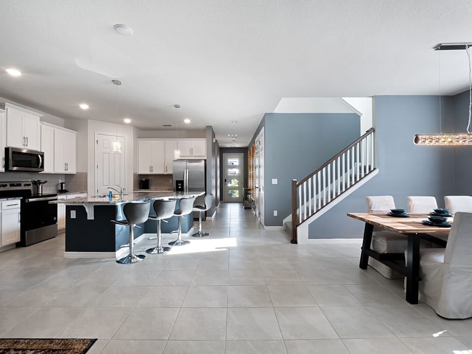 Spacious Downstairs Living Area with Full Size Kitchen, Barstools, and Dining Table