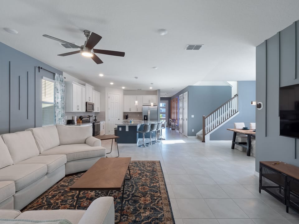 Spacious Downstairs Living Area with Comfy Soda, Flat Screen TV, Full Size Kitchen, Barstools, and Dining Table