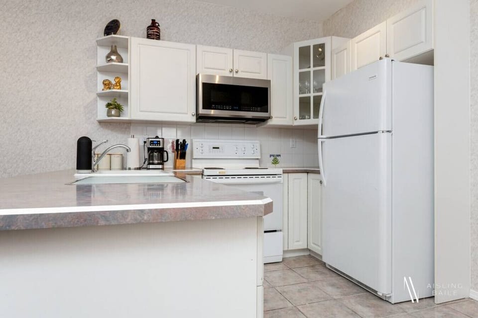 Full kitchen with a drip coffee machine, ground coffee, tea, sugar, and basic condiments (ketchup, mustard, relish.)