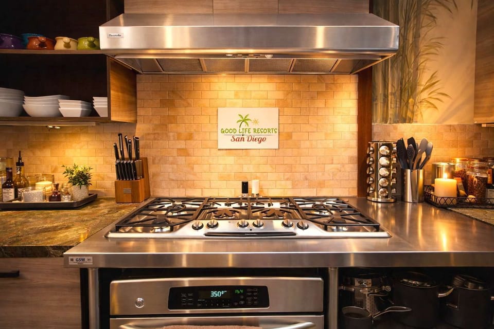 Chef-Style Gourmet Kitchen – Modern Gas Range, Stainless Steel Finishes, and Warm Ambient Lighting Creating the Perfect Space for Cooking & Entertaining