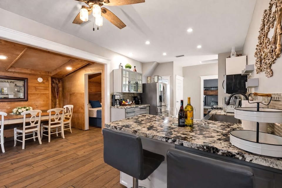 Open-Concept Kitchen & Dining with Granite Island, Bar Seating & Seamless Flow into Warm Rustic Dining Space — Perfect for Entertaining