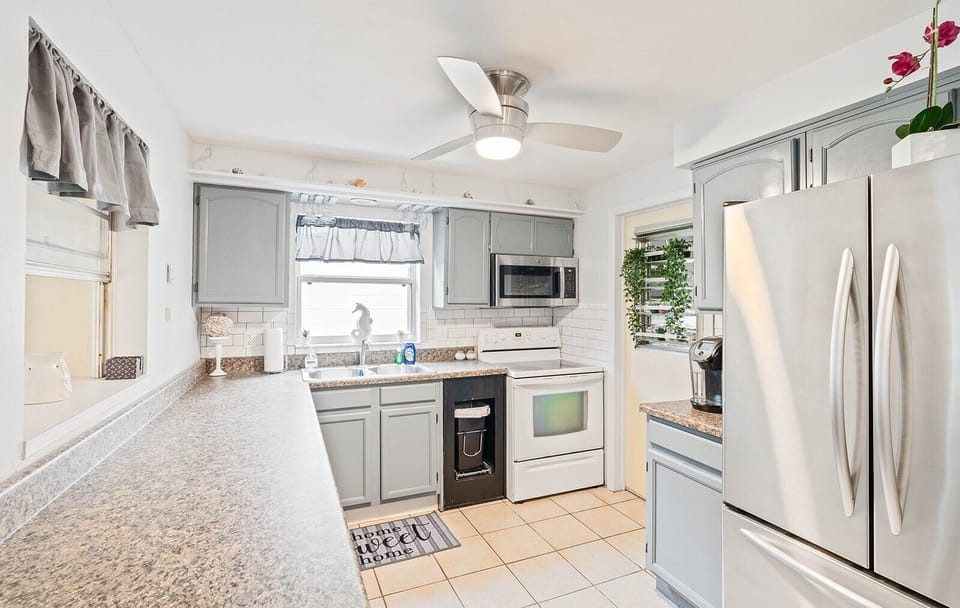 Well-lit kitchen with modern appliances,  counter space and cooking essentials.