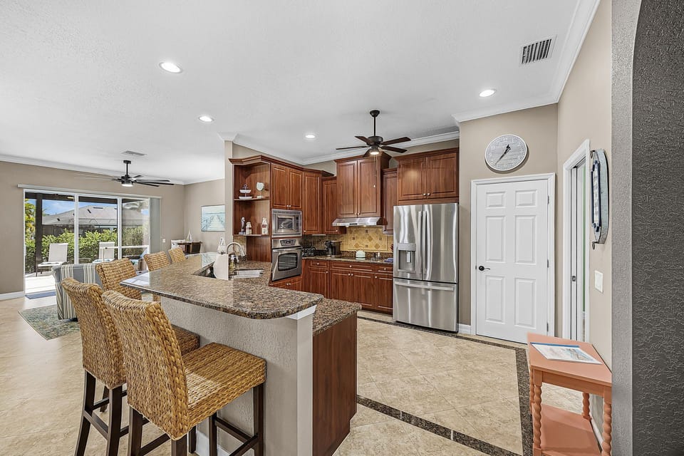 The kitchen has stainless steel appliances & additional seating at the breakfast bar