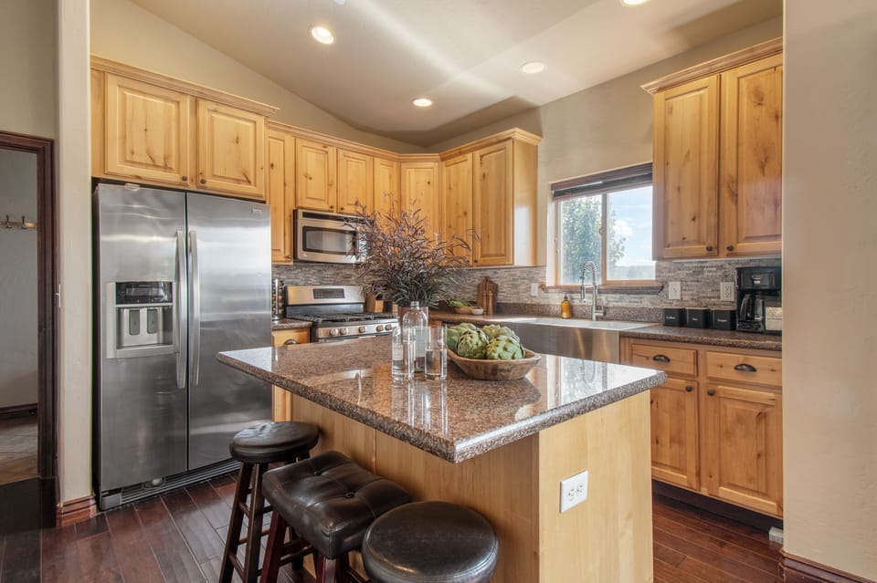 Kitchen with modern appliances and an island with barstool seating.