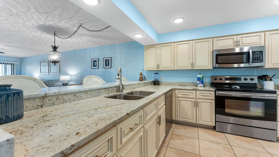 Spacious kitchen area with counter and sink plus ample cabinetry.
