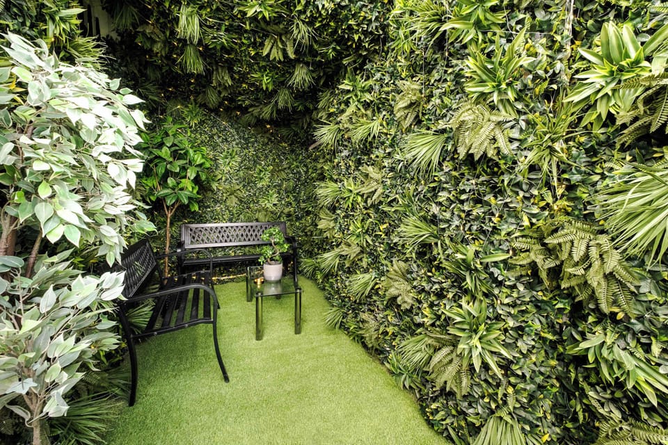 Patio | Step outside to our outdoor patio, where you can unwind in a comfortable seating area decorated with wall plant covered with warm LED fairy lights creating a nice evening ambiance for a cozy atmosphere.
