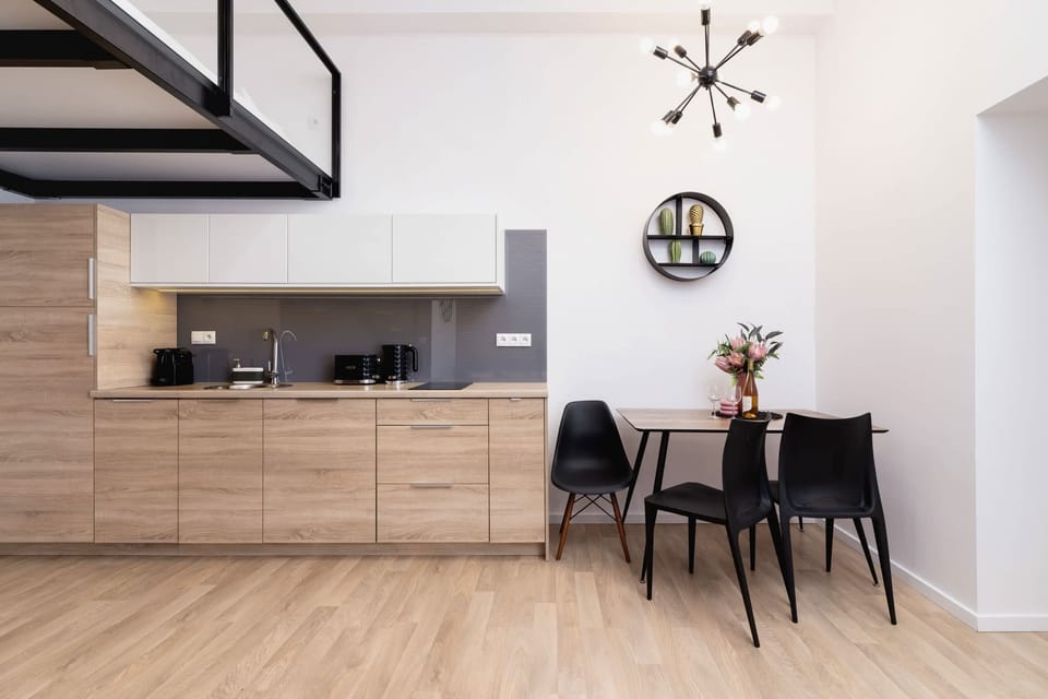 A sleek kitchen with modern appliances and glossy white cabinets. The open layout offers plenty of room for cooking and gathering.