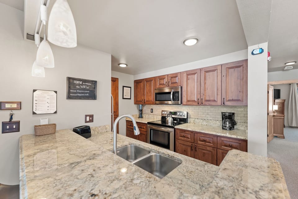 Full size kitchen with stainless steel appliances and granite countertops.