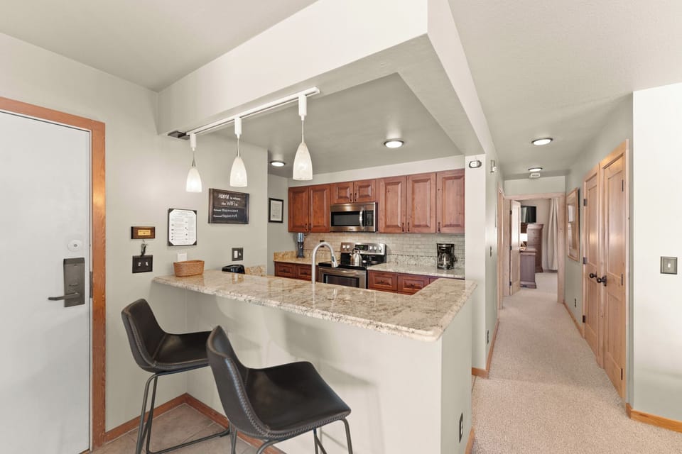 Full size kitchen with stainless steel appliances and granite countertops.
