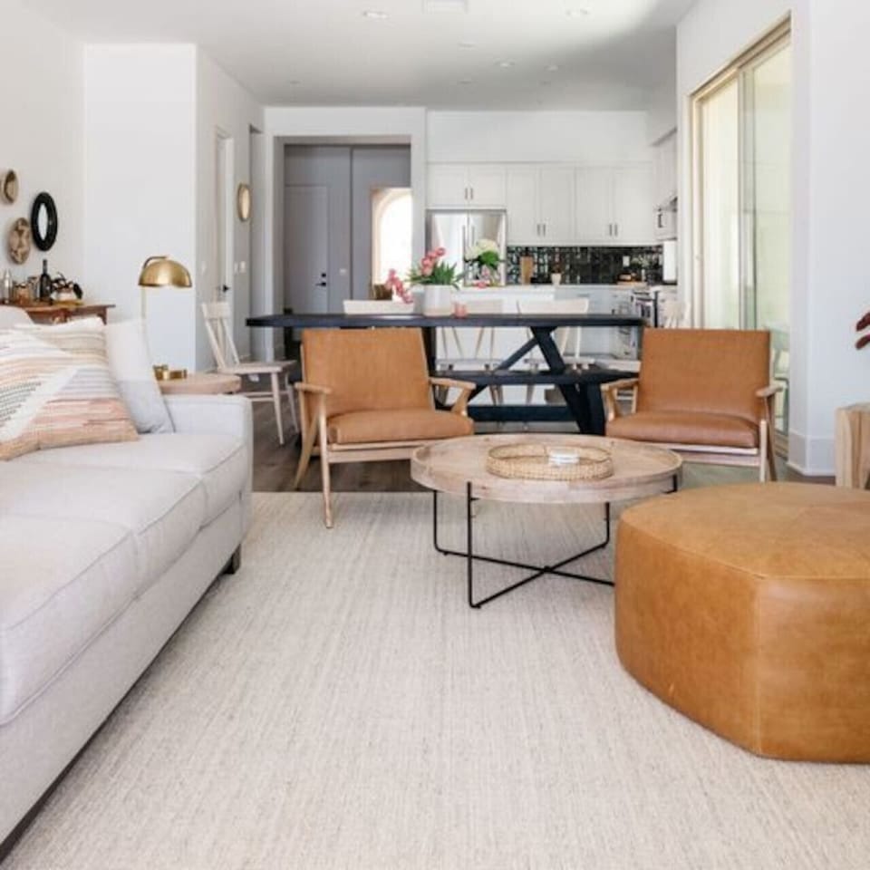 Open living & dining space w/ sofa seating, round table & warm decor touches