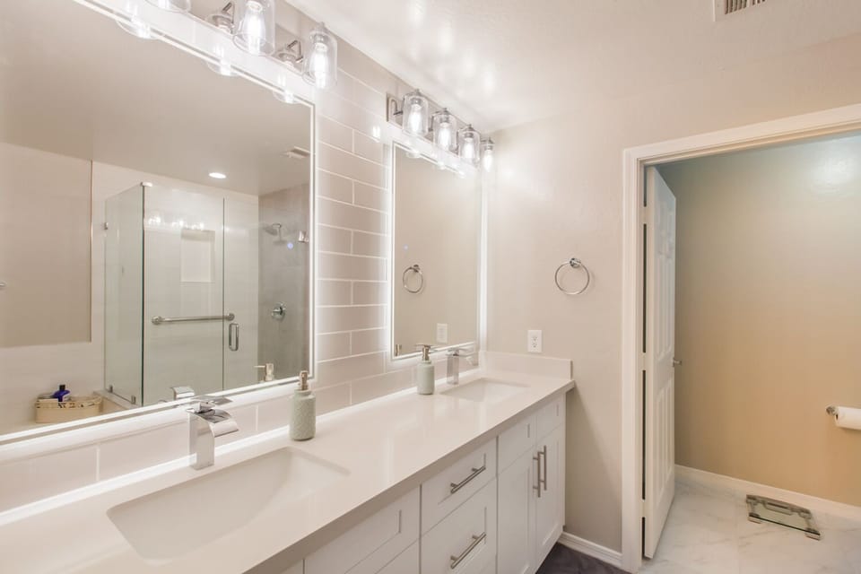 Primary Bathroom with dual sinks, separate shower and bathtub, heated mirrors