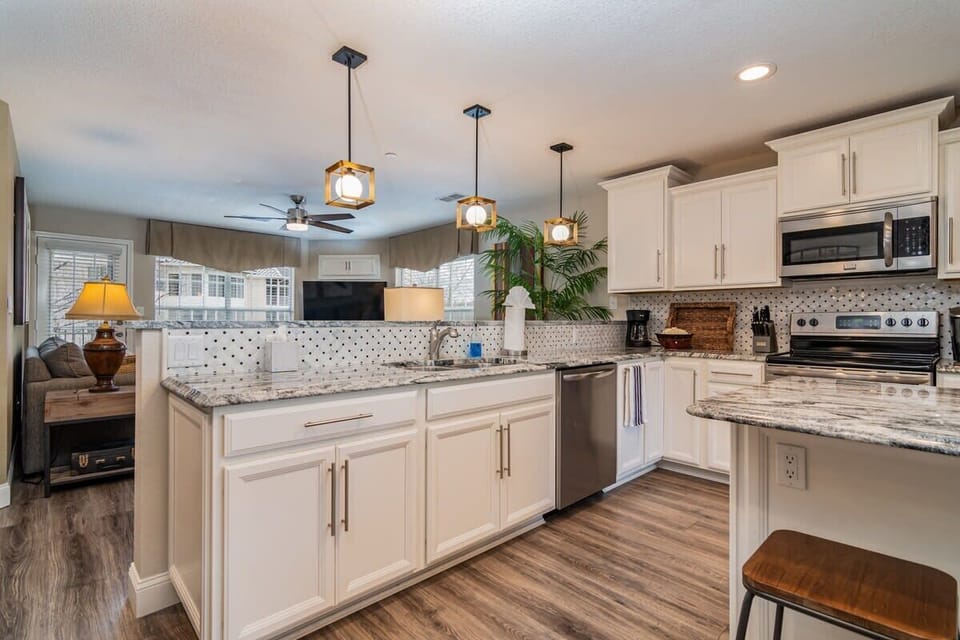 Granite countertops, stainless steel appliances, and well-stocked cooking supplies make this kitchen a dream to cook in!