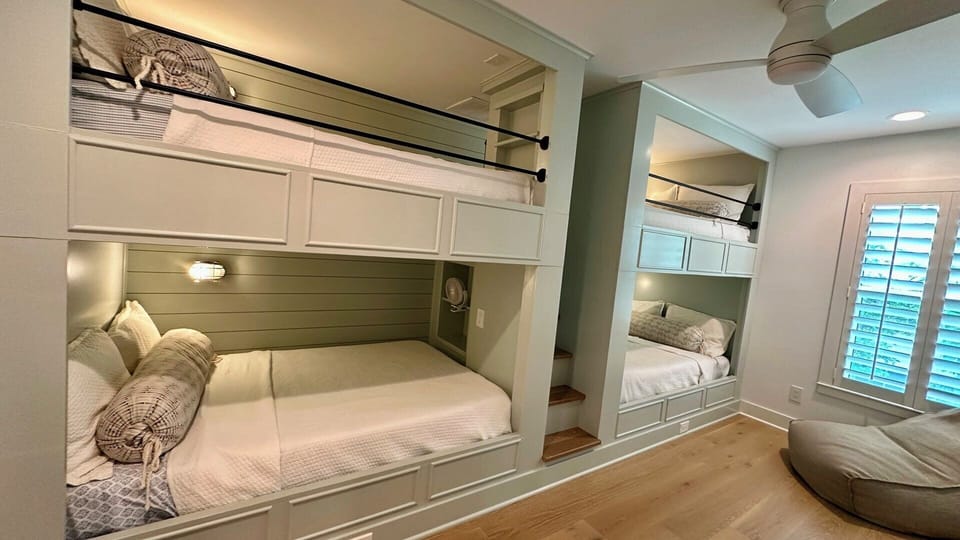 The custom bunk room has 4 Full beds, a Smart TV and poof chair.