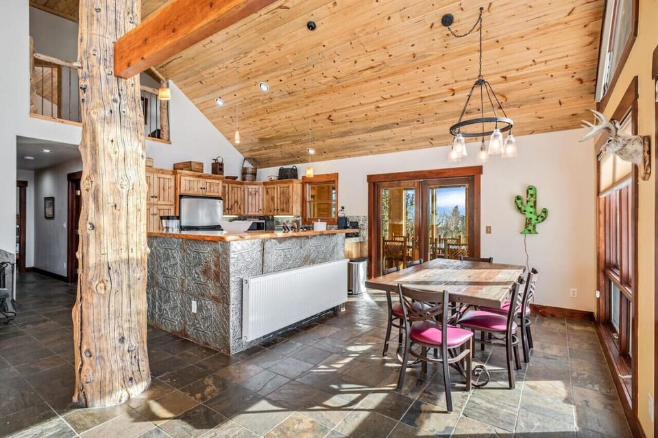 Open dining and kitchen area with high ceilings and warm lighting