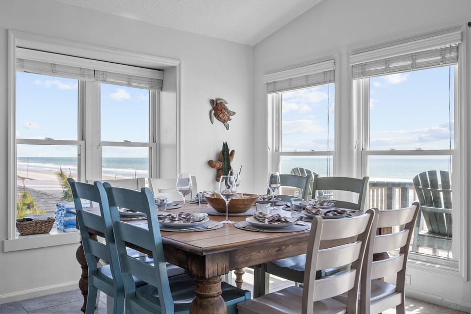 Enjoy a home-cooked meal at a table for 8 surrounded by views of the ocean and beach.