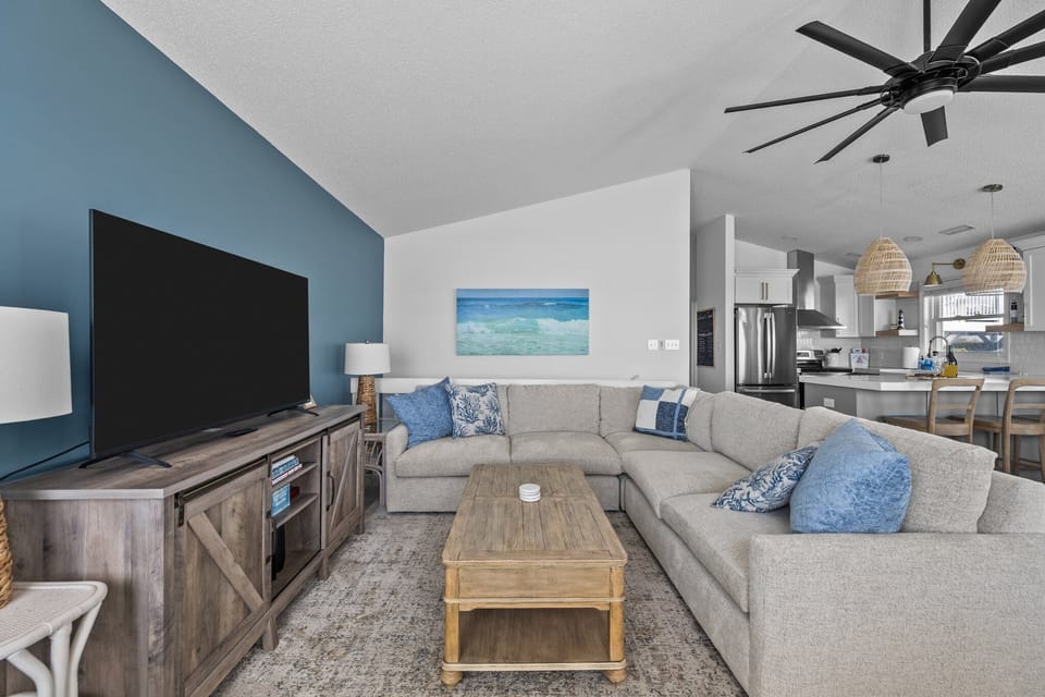 A side living room has a brand new Arhaus sectional and two swivel chairs.
