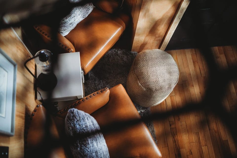 A cozy cabin seating nook with plush chairs, natural light, and a touch of rustic elegance.
