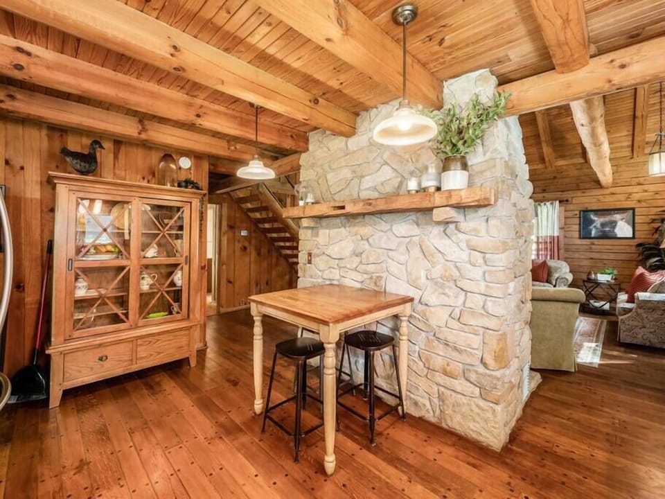 Dine in the cozy dining area with a stunning stone fireplace.