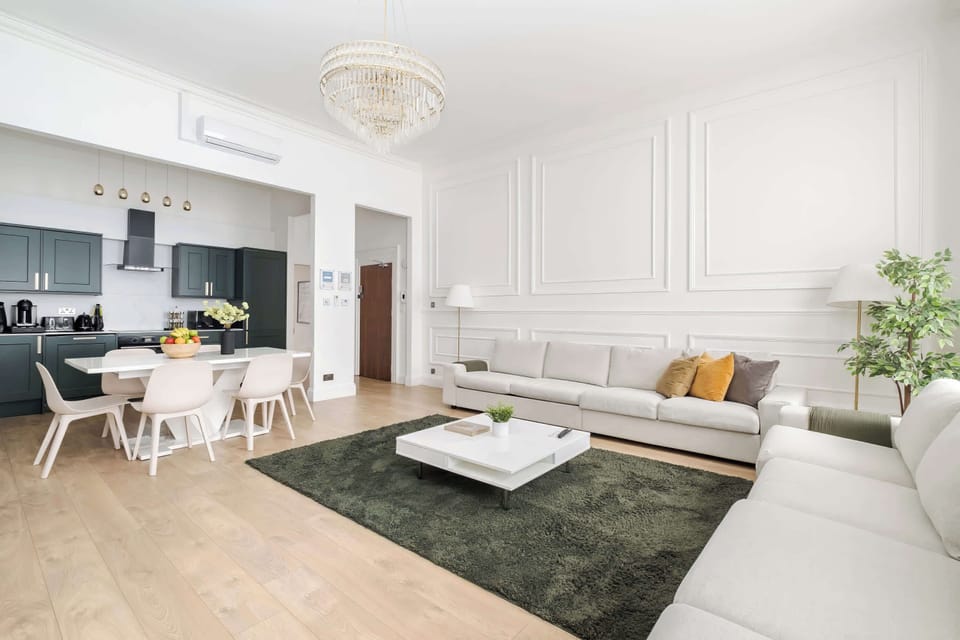 Living Room | A luxury retreat in our spacious living room with high ceilings, a 90 inch Smart LED TV, and full air conditioning for year round comfort. Relax in a perfectly curated, elegant setting with premium furnishings and a calm.