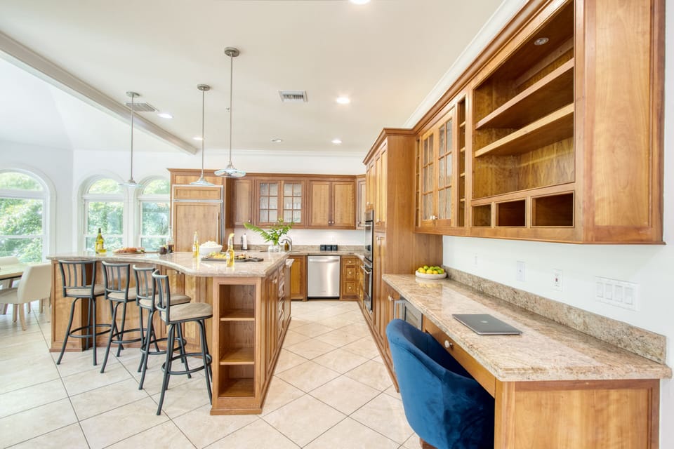 Spacious kitchen with bar seating and a workspace.