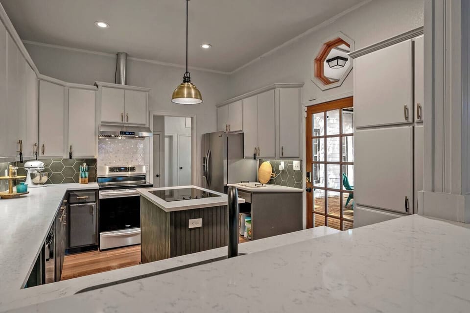 Kitchen has white quartz counter tops and new appliances such as Induction stove and high powered vent hood. Farm house sink. Lots of space and open to family room