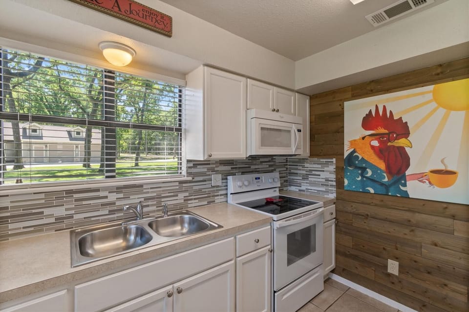 The tidy kitchen is equipped with every cooking need and appliances.