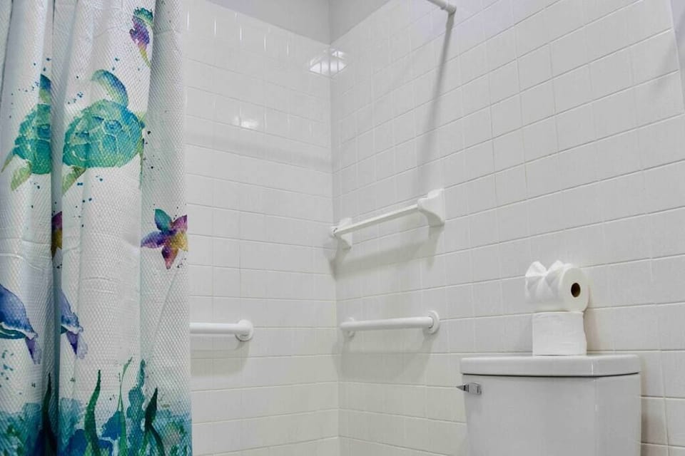 Newly renovated full bathroom featuring tile shower