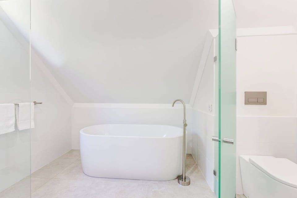 Fresh, modern, and thoughtfully designed, the main bathroom provides a spacious walk-in shower, a freestanding bathtub, and contemporary finishes for everyday comfort.
