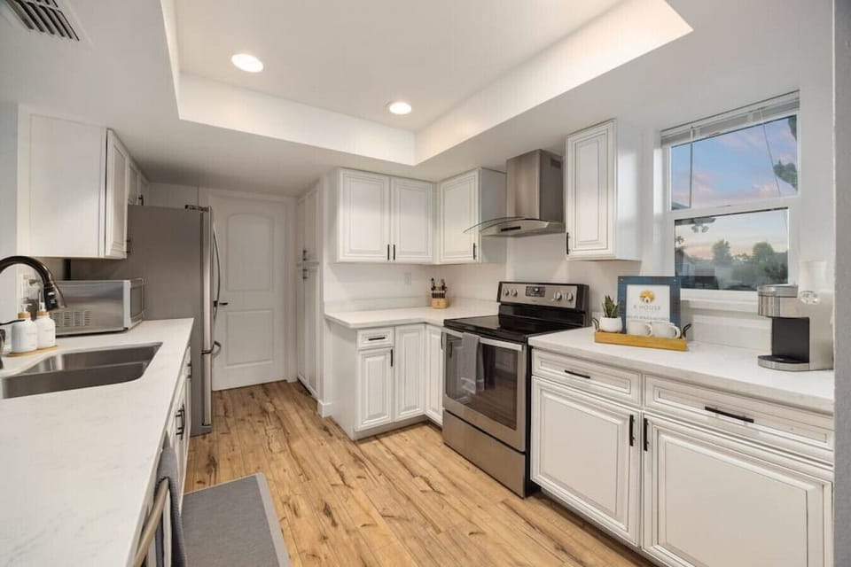 Clean white kitchen with stainless appliances and lots of counter space.
