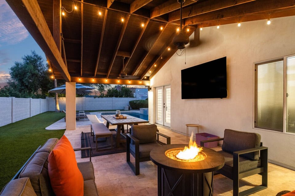 Covered patio with outdoor TV and fire feature, perfect for game nights outside.
